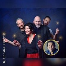 Vier Personen mit Wunderkerzen und ein Porträtfoto vor blauem Hintergrund.