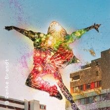 Silhouette einer springenden Person, gefüllt mit bunten Lichtern und Feuerwerk, vor einem städtischen Hintergrund.