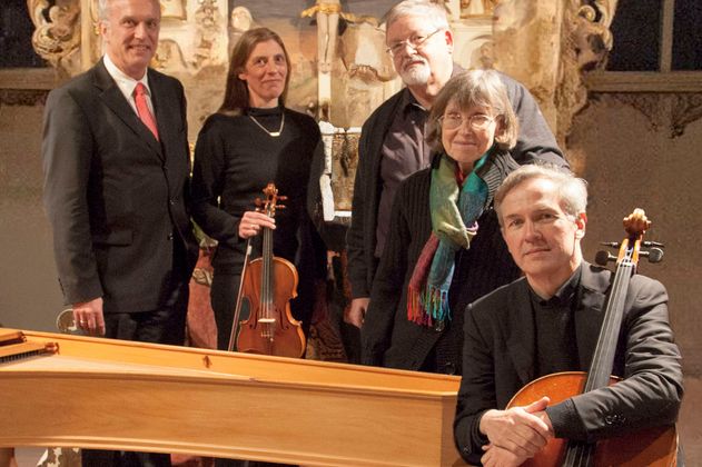 Fünf Musiker posieren mit Instrumenten vor einem Altar.