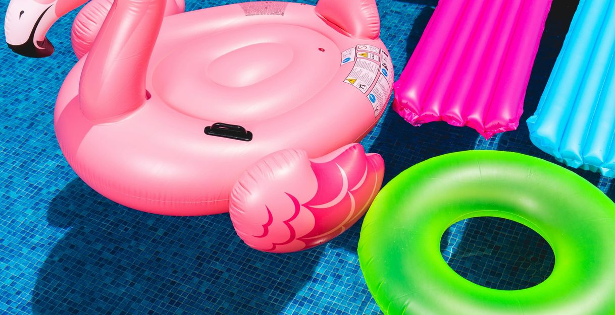 Aufblasbare Poolspielzeuge in einem blauen Pool.
