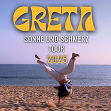 Person macht einen Handstand am Strand mit Meer im Hintergrund. Text: GRETA - Sonne und Schmerz Tour 2025.