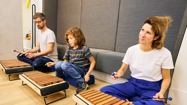 Drei Personen spielen Xylophon in einem Workshop.