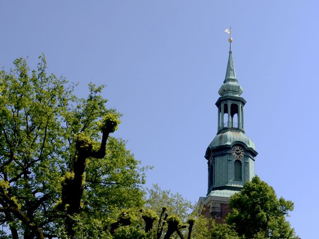 Turm der Dreieinigkeitskirche St. Georg mit Bäumen im Vordergrund.