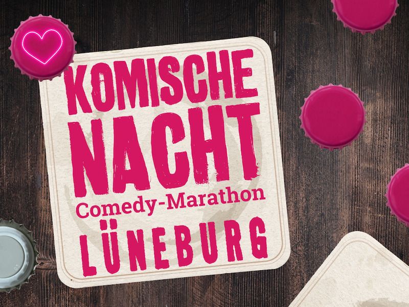 Untersetzer mit der Aufschrift 'Komische Nacht Comedy-Marathon Lüneburg' auf einem Holztisch mit Flaschendeckeln.