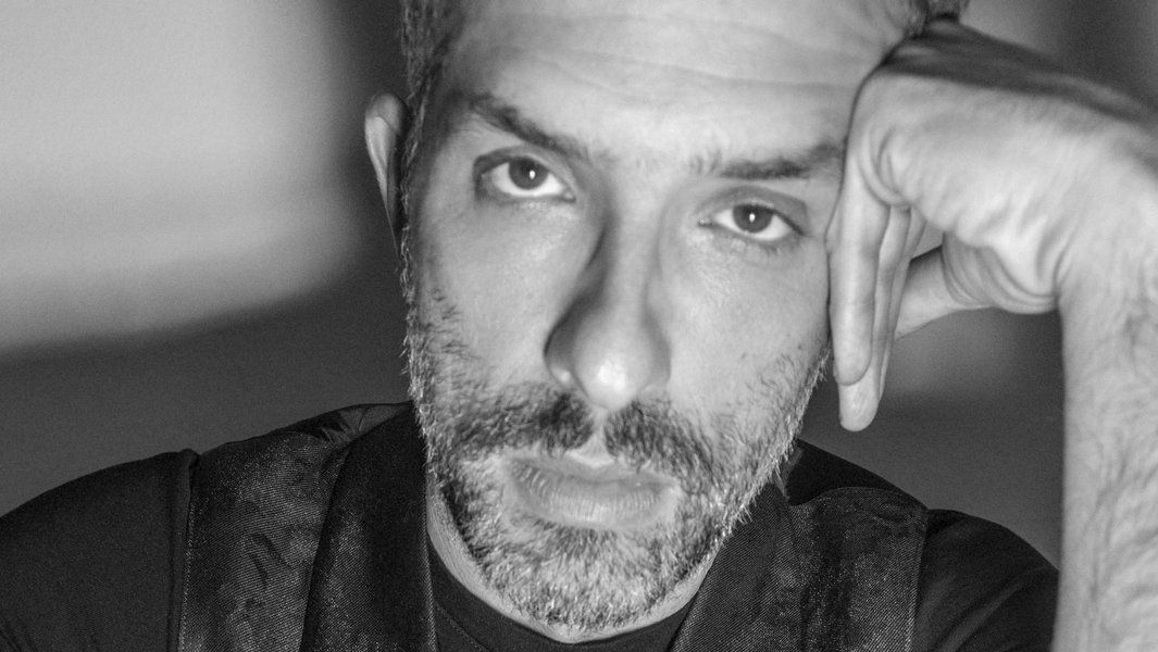 Porträt eines Mannes mit Bart, der nachdenklich in die Kamera schaut.