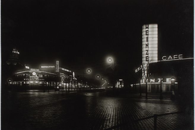 Nachtaufnahme der beleuchteten Reeperbahn in Hamburg mit Leuchtreklamen und Straßenlaternen.