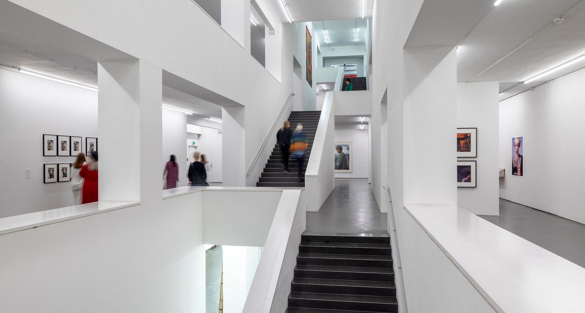 Innenansicht eines modernen Museums mit weißen Wänden und Treppen.