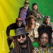 Gruppenfoto von Reggae-Künstlern vor einem gelb-grünen Hintergrund.