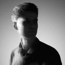 Schwarz-weiß Porträt eines Mannes im Profil mit unscharfem Hintergrund.