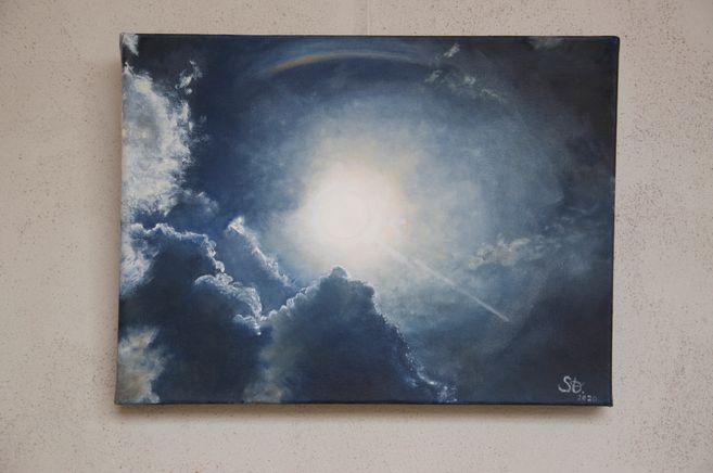 Der Wolken verhangene Himmel öffnet sich nach einem Gewitter und gibt den Blick frei auf ein faszinierendes Lichtphänomen.