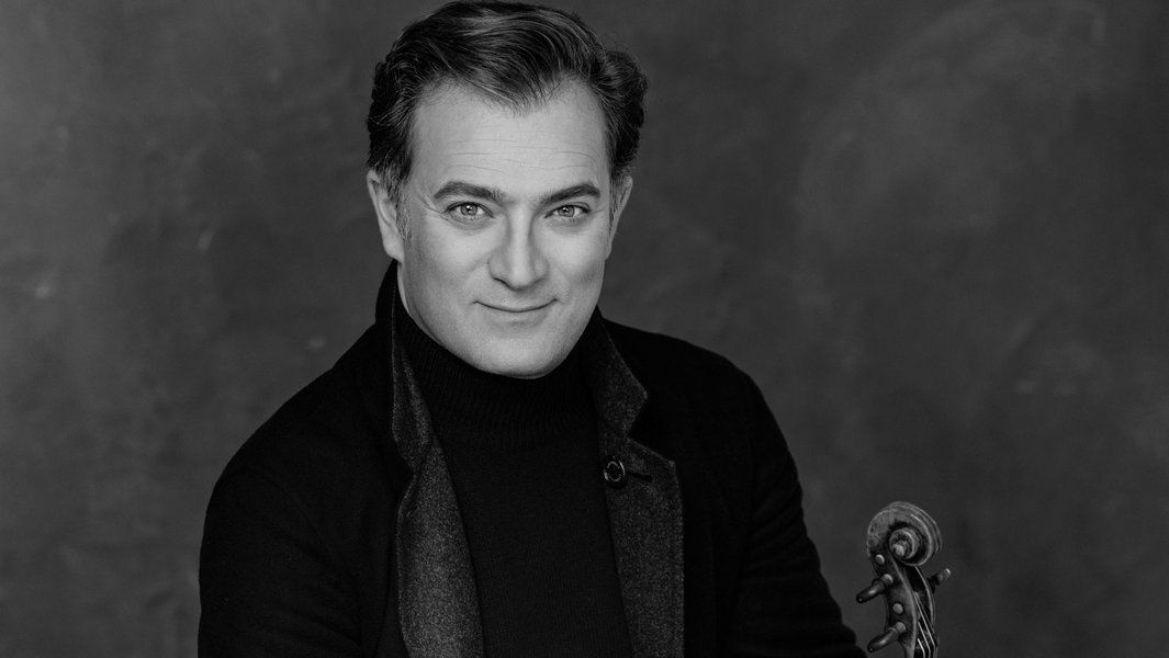 Schwarz-weiß Porträt eines Mannes mit Geige.