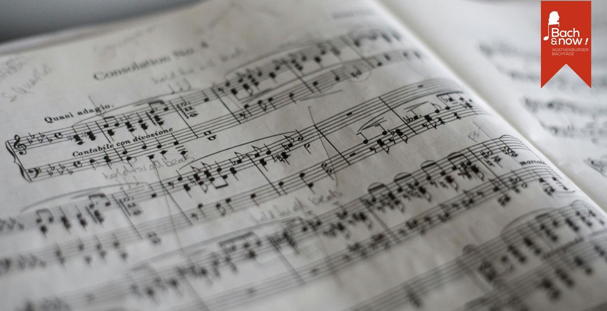 Nahaufnahme von handschriftlich bearbeiteten Notenblättern mit dem Logo der Agathenburger Bachtage in der Ecke.