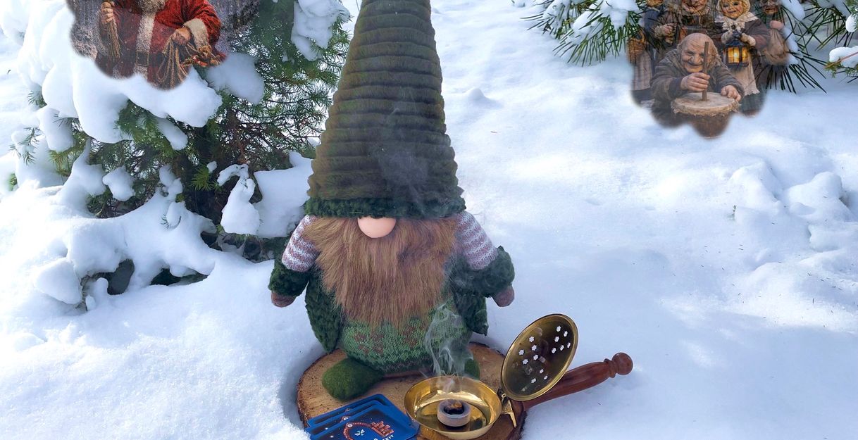Ein Wichtel steht im Schnee neben einem Räuchergefäß. Im Hintergrund sind weihnachtliche Figuren zu sehen.