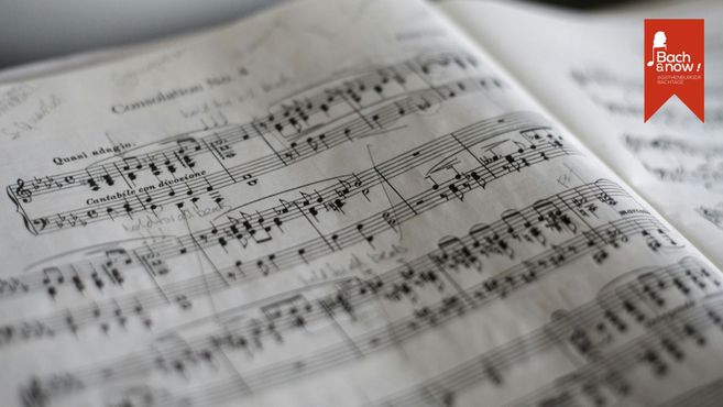 Nahaufnahme von handschriftlich bearbeiteten Notenblättern mit dem Logo der Agathenburger Bachtage in der Ecke.