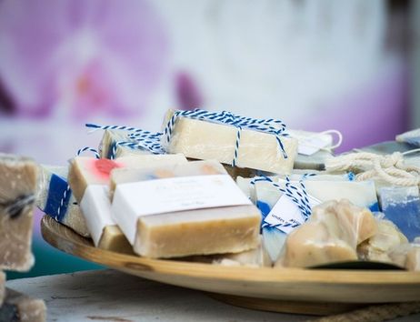 Ein Holztablett mit handgemachten Seifenstücken, die in Papier und Schnur verpackt sind.