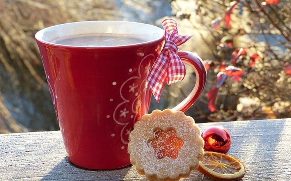Rote winterliche Tasse mit einem Plätzchen