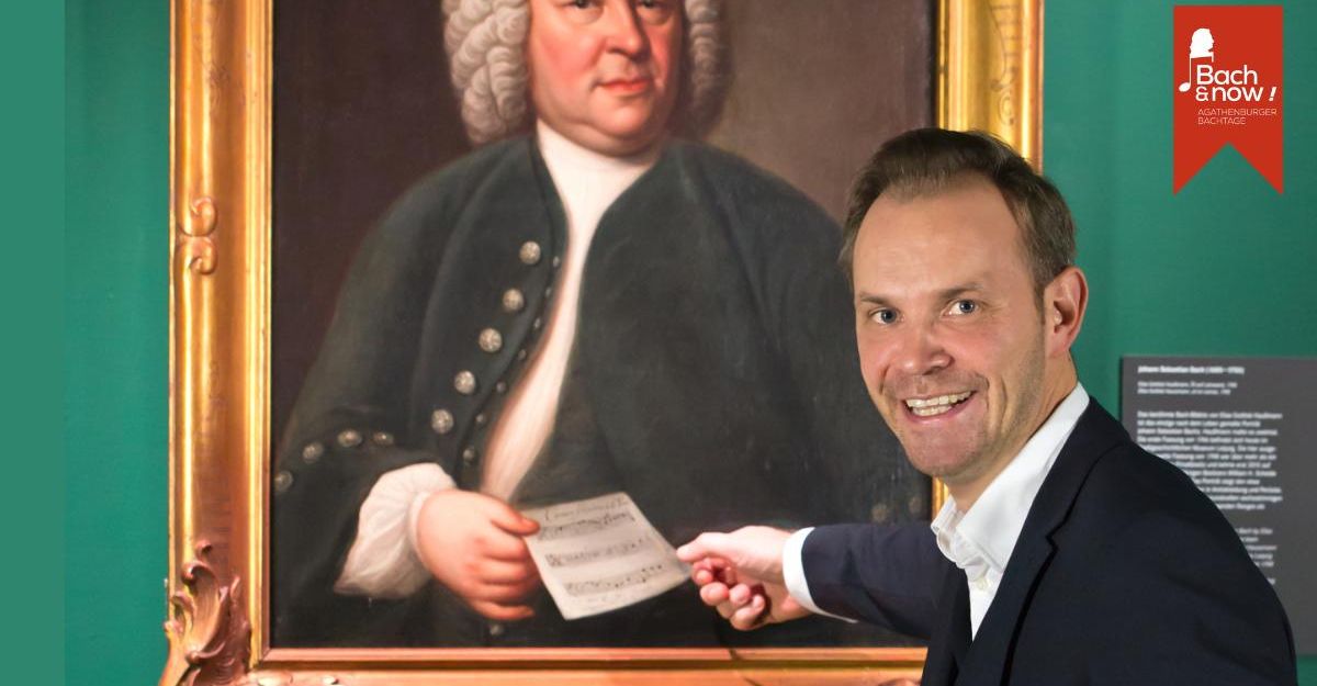 Ein Mann zeigt auf ein Gemälde von Johann Sebastian Bach in einem Museum.