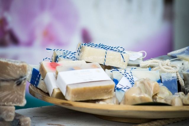 Ein Holztablett mit handgemachten Seifenstücken, die in Papier und Schnur verpackt sind.