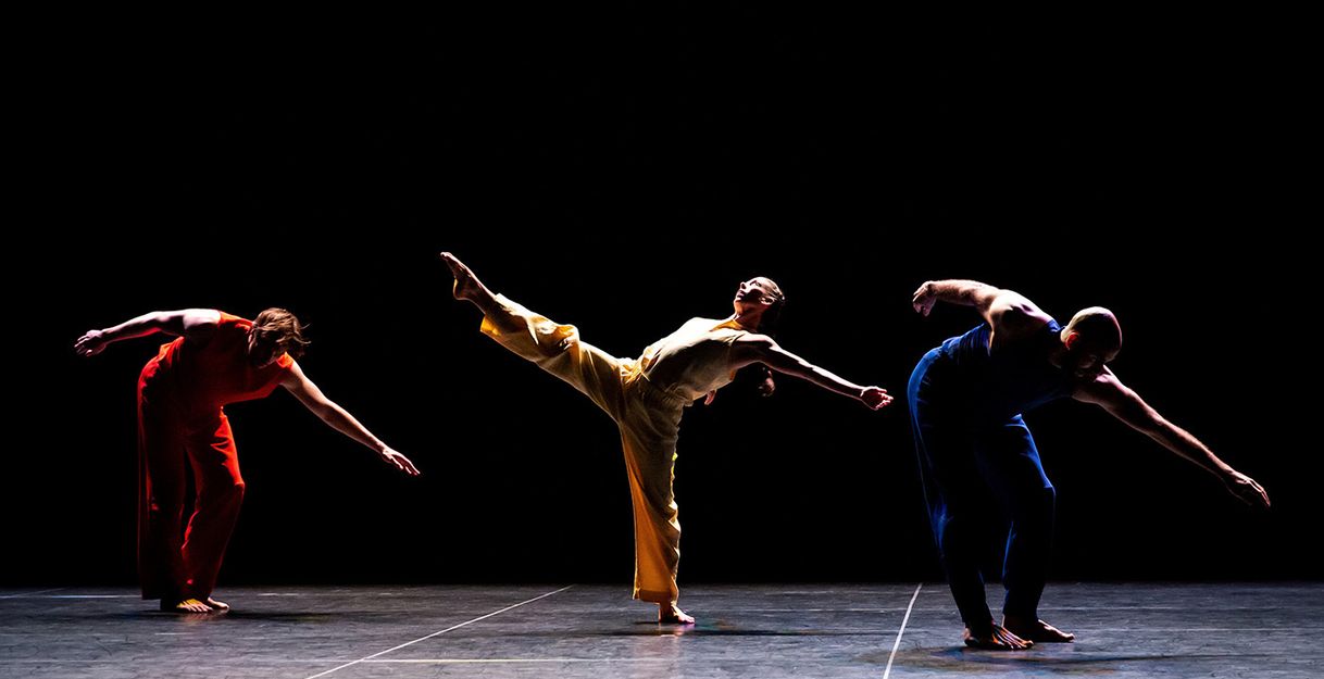 Performers Savannah Gaillard, Patrick Needham, Ashley Merker, Burr Johnson, Spencer Weidie, and Cecily Campbell dance virtuosically on stage, some jumping, others holding hands.