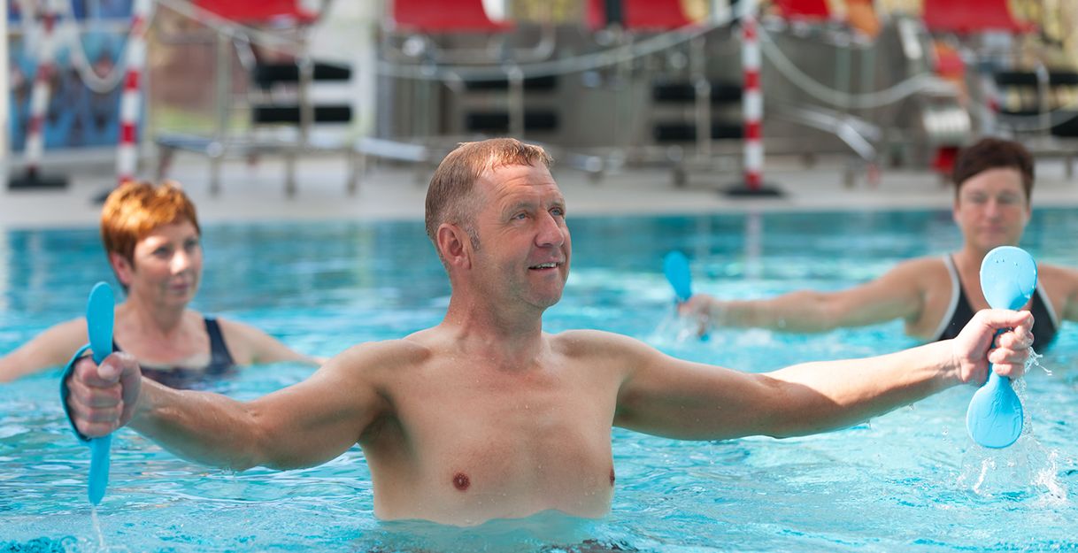 Menschen machen Aqua-Fitness-Übungen in einem Schwimmbad.
