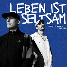 Zwei Männer in Sportbekleidung vor blauem Hintergrund mit dem Text 'Leben ist seltsam'.